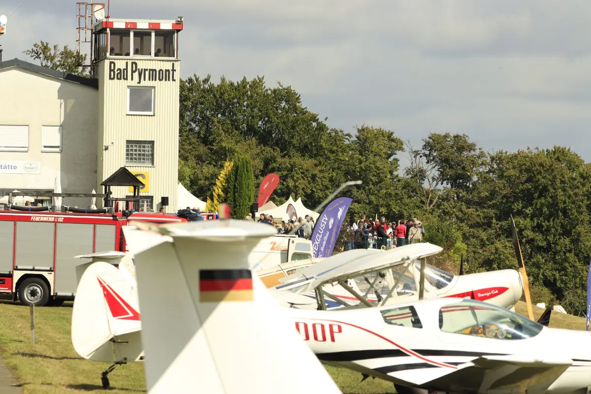 Tower des Flugplatzes Bad Pyrmont mit Besuchern und abgestellten Flugzeugen